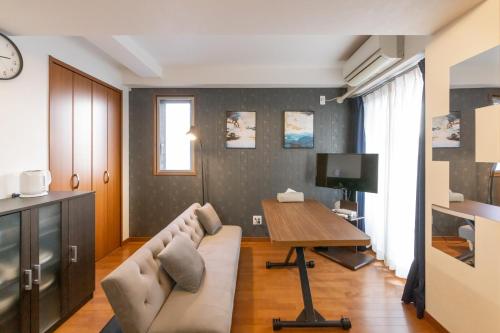 una sala de estar con un sofá y una mesa en Impulse Imazato, en Osaka