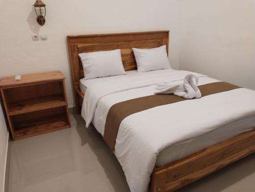 a bedroom with two beds and a night stand at Nan Bungalows Tetebatu in Tetebatu