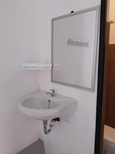 a bathroom with a white sink and a mirror at Nan Bungalows Tetebatu in Tetebatu