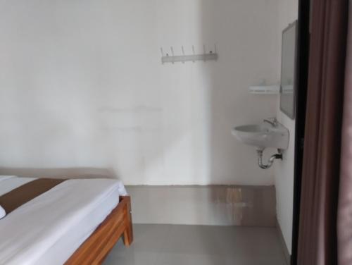 a bedroom with a bed and a sink at Nan Bungalows Tetebatu in Tetebatu