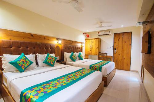 a hotel room with two beds in a room at Treebo Anam International in Mumbai