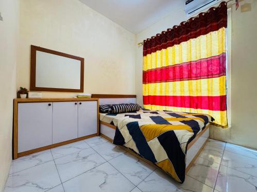 a bedroom with two beds and a window at Mulia Homestay Syariah Pasuruan in Randusari