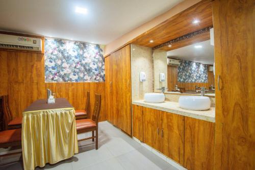 a bathroom with a sink and a table and a mirror at Treebo Anam International in Mumbai