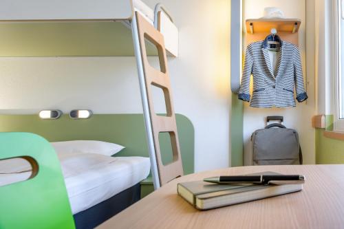 a bedroom with a bunk bed and a desk with a book at Ibis budget Hamburg City Ost in Hamburg