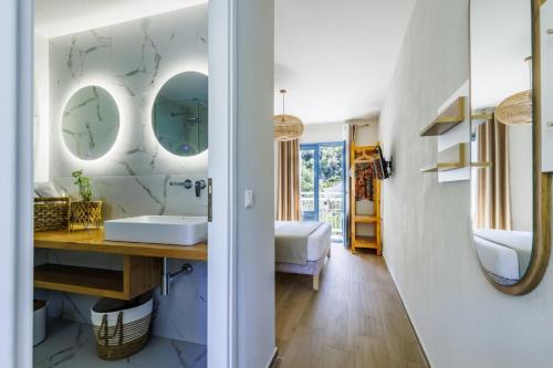 a bathroom with a sink and two mirrors at Limnonari Double room in Skopelos Town