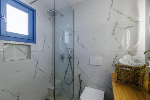 a bathroom with a shower with a toilet and a window at Limnonari Double room in Skopelos Town