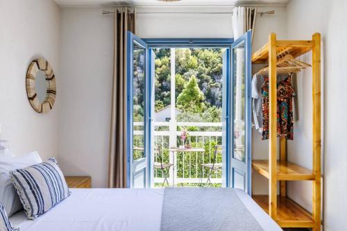 a bedroom with a bed and a large window at Limnonari Double room in Skopelos Town