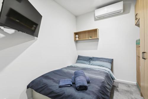 a small bedroom with a bed and a tv at Cozy Stays - Private Rooms in Adelaide CBD with Shared Facilities in Adelaide