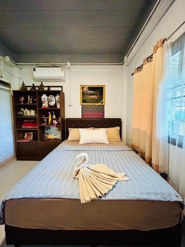 a bedroom with a bed with a towel on it at The Dreamcatcher Hostel Nathon SamuiSunset in Nathon