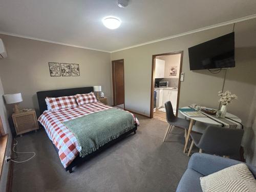 a bedroom with a bed and a desk with a computer at #1 Waddell Studio Apartment in Canowindra