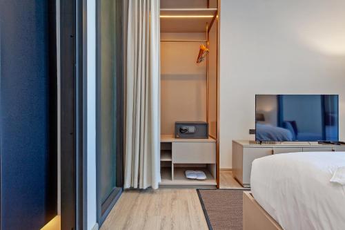 a bedroom with a bed and a tv in a room at Edge Central Pattaya Sea view High Floor 23,26 in Pattaya