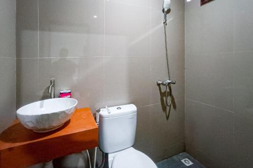 a bathroom with a white sink and a toilet at RedDoorz at RRR Guesthouse Mataram in Tjakranegara