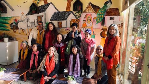 a group of people standing in front of a mural at Rudram Hotel Yoga & Ayurveda Retreat in Rishīkesh