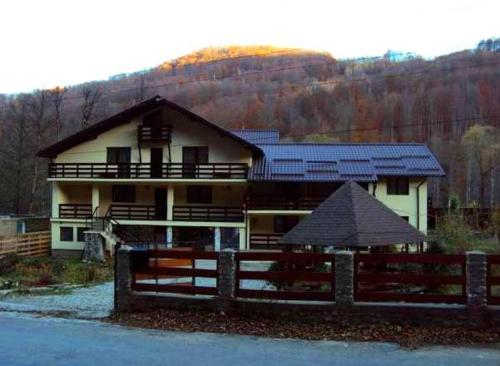 a house with a fence in front of it at Pensiunea Ciobanelu in Malaia
