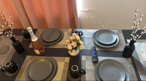a table with plates and vases on top of it at London House near Greenwich, Free Parking, Free WIFI in London
