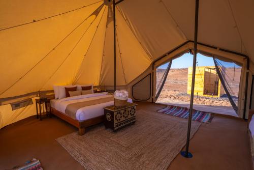 a large tent with a bed in the middle of a room at Twilight Dunes by Miracle Oman in Badīyah