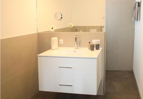 a bathroom with a white sink and a mirror at Ferienhaus Viktoria in Abfaltersbach