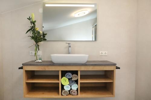 a bathroom vanity with a sink and a mirror at Ferienhaus Viktoria in Abfaltersbach