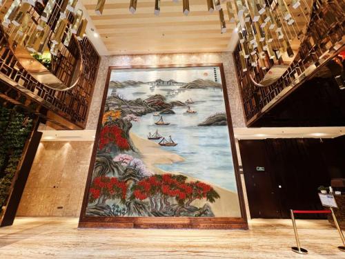 a large mural on the wall in a room with stairs at Menshine Gloria Plaza Hotel in Shantou