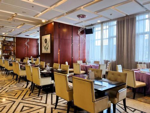 a dining room with tables and chairs in a room at Menshine Gloria Plaza Hotel in Shantou