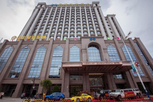 a large building with cars parked in front of it at Menshine Gloria Plaza Hotel in Shantou