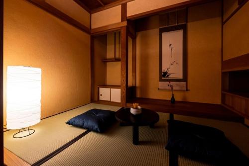 a room with a bed and a table and a lamp at Casa Villa 連歌屋 Wooden detached house in Dazaifu in Dazaifu