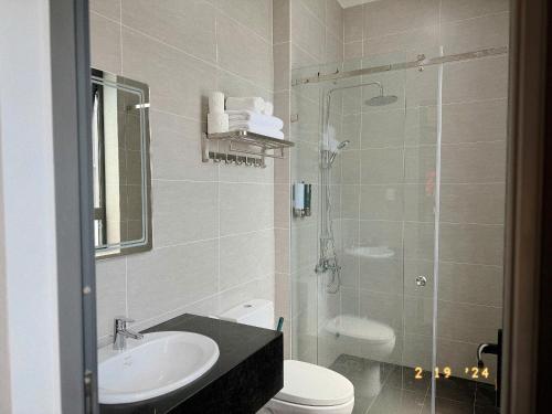 a bathroom with a shower and a toilet and a sink at Sunflower Garden Homestay Đà Lạt in Xuan An