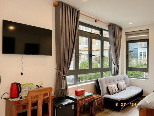 a living room with a couch and a large window at Sunflower Garden Homestay Đà Lạt in Xuan An