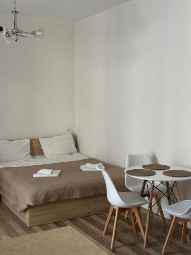 Un dormitorio con una cama y dos sillas y una mesa. en EL-MI, en Borjomi