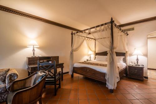 a bedroom with a canopy bed and a desk at Promisedland Resort & Lagoon in Shoufeng