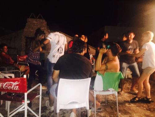 a group of people sitting around in chairs at night at Wayra Hostel in La Rioja