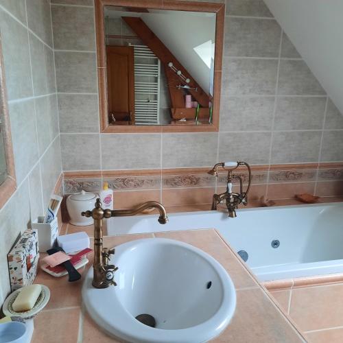 une salle de bain avec un lavabo et une baignoire dans l'établissement courseullescommealamaison, à Courseulles-sur-Mer