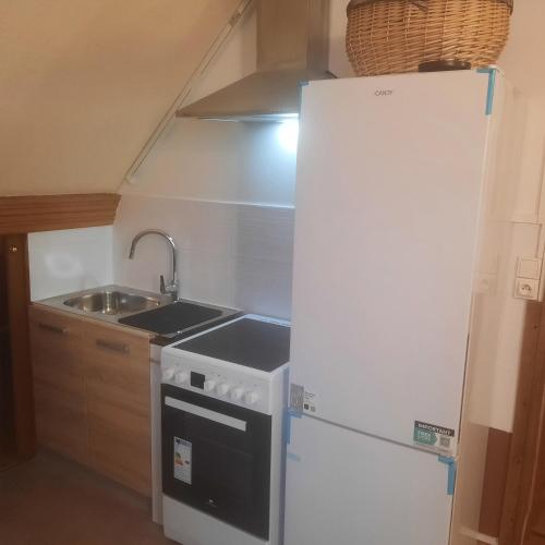 une cuisine avec un réfrigérateur blanc et un évier dans l'établissement courseullescommealamaison, à Courseulles-sur-Mer