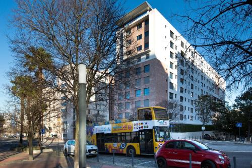 a double decker bus parked in front of a building at Oriente Marina Housing by APT IIN in Lisbon