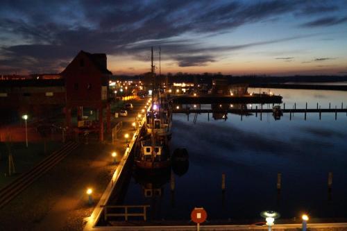 a boat docked in a harbor at night at Speicher Barth - Superior-Hotel in Barth