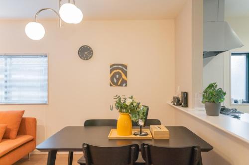 a dining room and living room with a table and chairs at 旅タイム 住吉朱雀 in Osaka