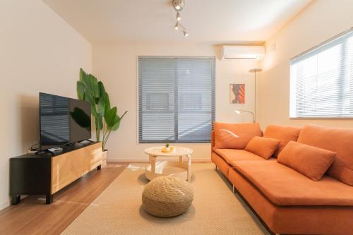a living room with a couch and a tv at 旅タイム 住吉朱雀 in Osaka