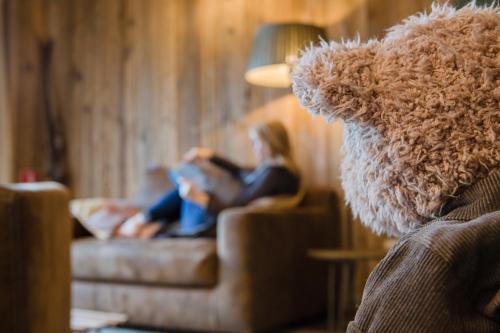 two people sitting on a couch with a teddy bear at La Couette de l'Ours in Aywaille