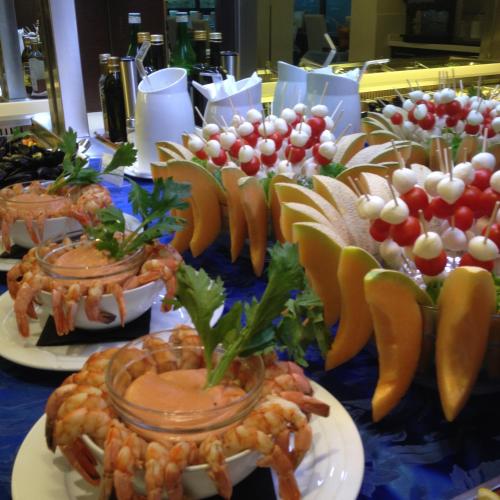 a buffet of food with shrimp and vegetables on plates at Hotel Bellevue in Lignano Sabbiadoro