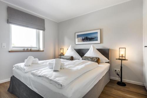 un grand lit blanc dans une chambre avec une fenêtre dans l'établissement Deichlodge-4, à Büsumer Deichhausen