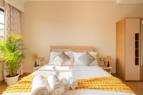 a bedroom with a large bed with towels on it at ELIVAAS Kamerios Maris 1BHK Apartment with Jacuzzi in Goa