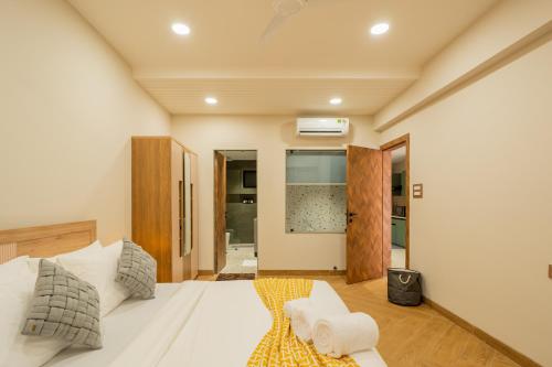 a bedroom with a white bed and wooden floors at ELIVAAS Kamerios Maris 1BHK Apartment with Jacuzzi in Goa