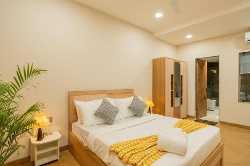 a bedroom with a bed and a potted plant at ELIVAAS Kamerios Maris 1BHK Apartment with Jacuzzi in Goa