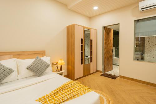 a bedroom with a white bed and a large window at ELIVAAS Kamerios Maris 1BHK Apartment with Jacuzzi in Goa