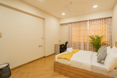 a bedroom with a bed and a large window at ELIVAAS Kamerios Maris 1BHK Apartment with Jacuzzi in Goa