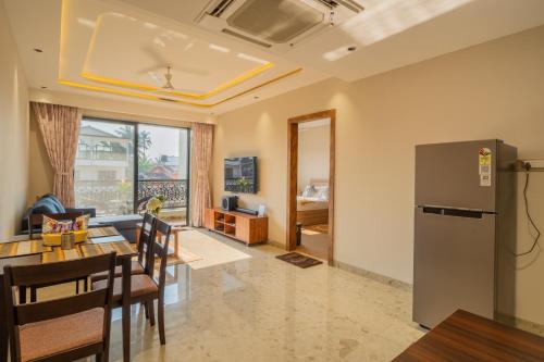 a kitchen and a living room with a refrigerator at ELIVAAS Kamerios Maris 1BHK Apartment with Jacuzzi in Goa