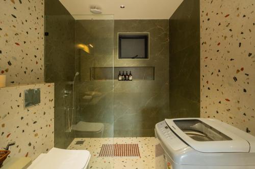 a bathroom with a shower with a toilet in it at ELIVAAS Kamerios Maris 1BHK Apartment with Jacuzzi in Goa