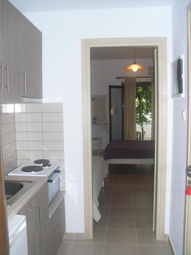 a kitchen with a door open to a room at Guesthouse Irene in Afissos