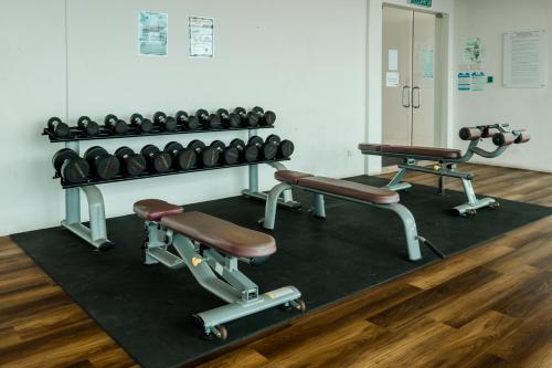 a gym with two rows of dumbbells and weights at Regatta at Kozi Square Kuching in Kuching
