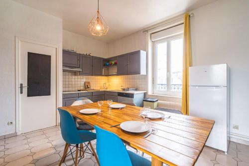 une cuisine avec une table en bois et des chaises bleues dans l'établissement Grand appartement Reims gare centre 4 chambres, à Reims